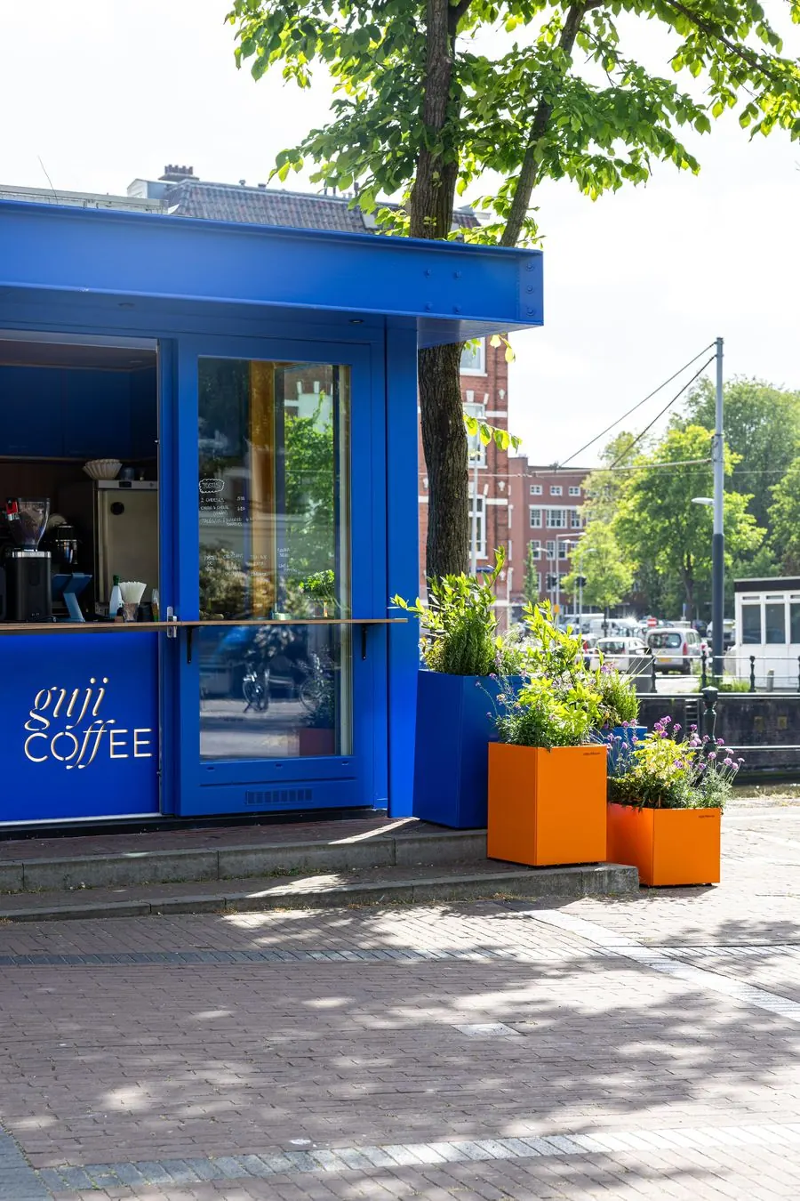 The blue Guji Coffee Kiosk with orange planters on Zoutkeetsplein