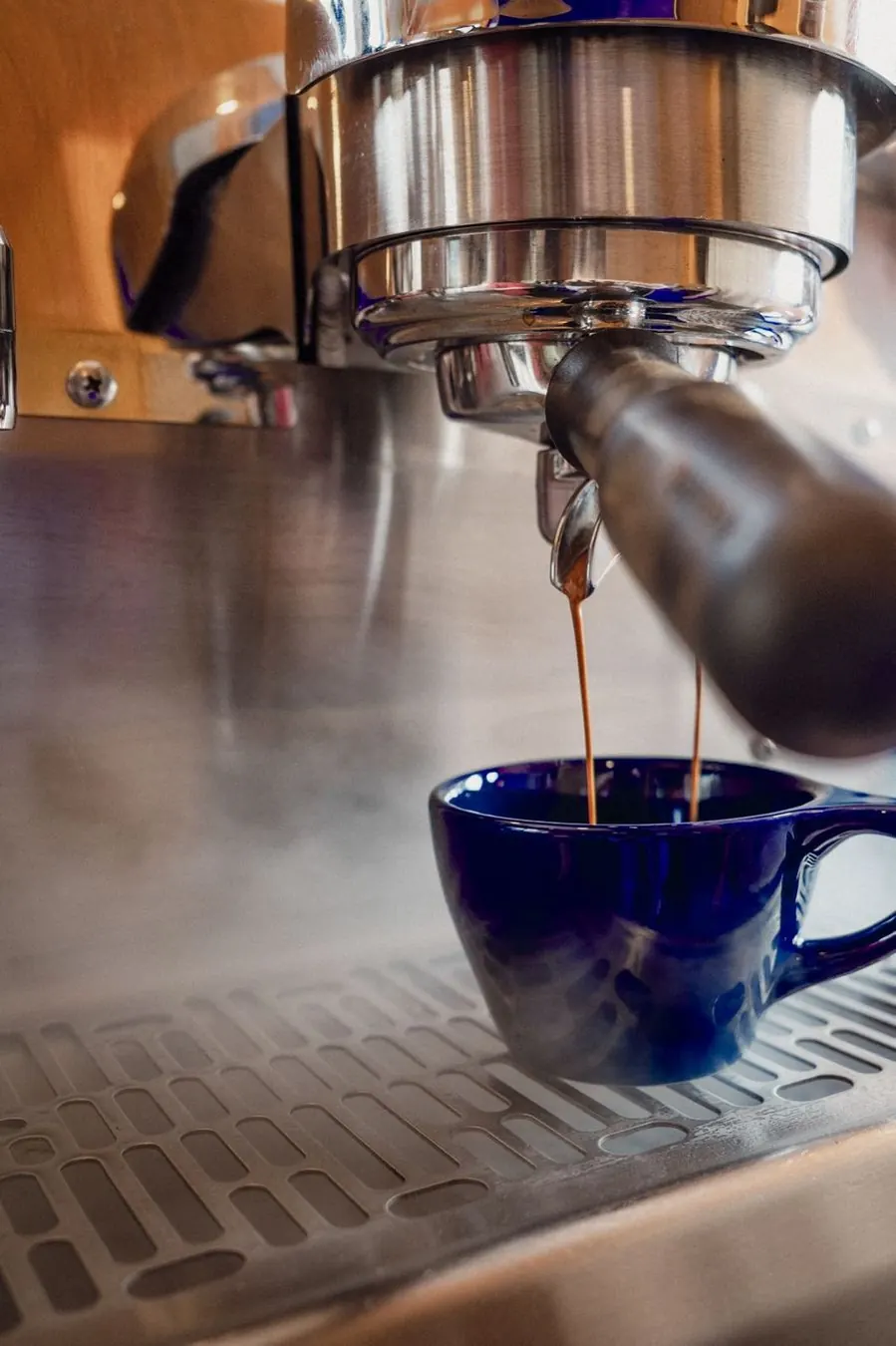 Espresso pouring into a blue cup at the Guji Coffee Kiosk